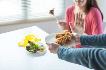diet woman eateing fresh vegetable and  reject chicken meal