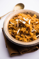 Wheat Laapsi/Lapsi/Shira/Halwa is an Indian sweet dish made of broken wheat or Daliya pieces and ghee along with nuts, raisins and dried fruits. It's a healthy food. served in a bowl, selective focus