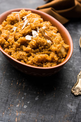 Wheat Laapsi/Lapsi/Shira/Halwa is an Indian sweet dish made of broken wheat or Daliya pieces and ghee along with nuts, raisins and dried fruits. It's a healthy food. served in a bowl, selective focus