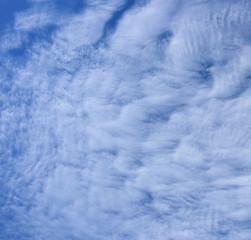 Faszinierende vom Winde verwehte weiße Wolken am blauen Himmel