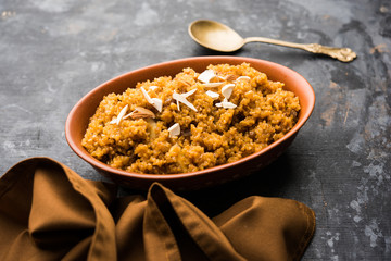 Wheat Laapsi/Lapsi/Shira/Halwa is an Indian sweet dish made of broken wheat or Daliya pieces and ghee along with nuts, raisins and dried fruits. It's a healthy food. served in a bowl, selective focus