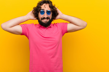 young crazy man feeling stressed, worried, anxious or scared, with hands on head, panicking at...