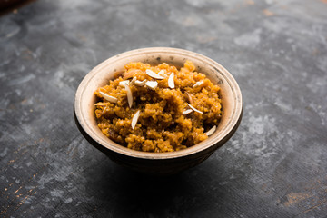 Wheat Laapsi/Lapsi/Shira/Halwa is an Indian sweet dish made of broken wheat or Daliya pieces and ghee along with nuts, raisins and dried fruits. It's a healthy food. served in a bowl, selective focus