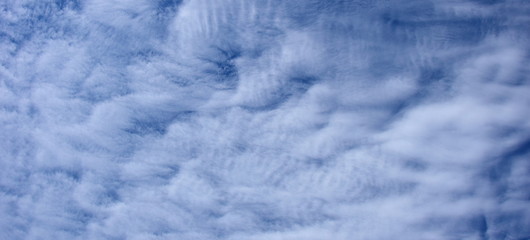 Faszinierende vom Wind verwehte Wolken am blauen Himmel