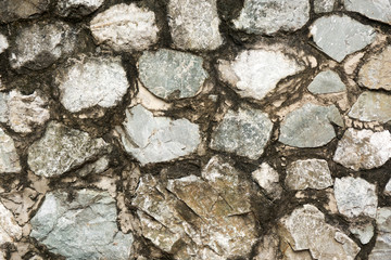 Old rough stone wall. Rock gray background.
