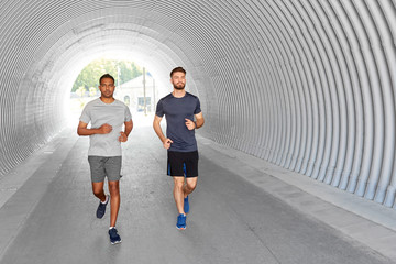 fitness, sport and healthy lifestyle concept - young men or male friends running outdoors
