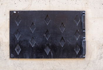 Trappe en acier dans mur de pierre