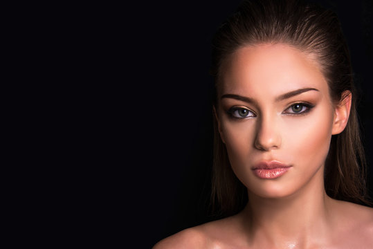 Beauty portrait of model with natural nude make-up. Fashion shiny highlighter on skin, wet look perfect skin,  lips make-up , close up in studio