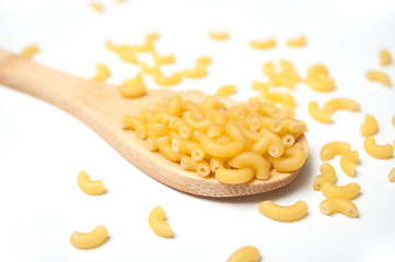 Closeup of raw pasta in a wooden spoon on white background