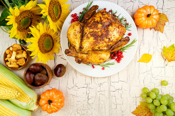Thanksgiving background. Cooked chicken or turkey with autumn vegetables for thanksgiving dinner on wooden table. Thanksgiving Day concept. Top view, copy space