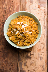 Wheat Laapsi/Lapsi/Shira/Halwa is an Indian sweet dish made of broken wheat or Daliya pieces and ghee along with nuts, raisins and dried fruits. It's a healthy food. served in a bowl, selective focus
