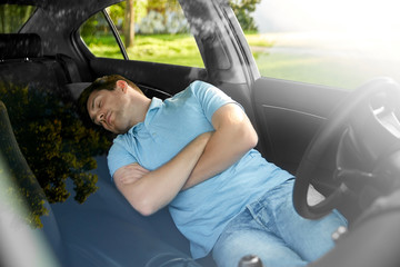 transport, rest and driving concept - tired man or driver sleeping in car