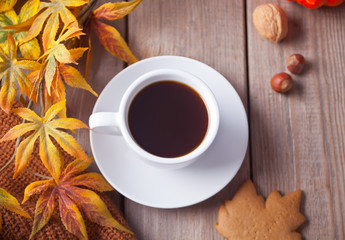 Cup of coffee, autumn leaves, cookies on the wooden table. Autumn harvest. Autumn concept. Top view.