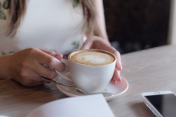cup of cappuccino in hands