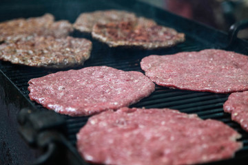 Grilling burgers and hot dogs on a huge grill outdoors.