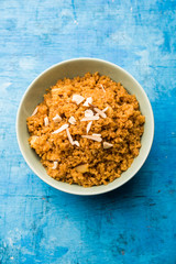 Wheat Laapsi/Lapsi/Shira/Halwa is an Indian sweet dish made of broken wheat or Daliya pieces and ghee along with nuts, raisins and dried fruits. It's a healthy food. served in a bowl, selective focus