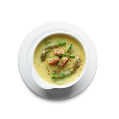 Green asparagus soup in white bowl isolated. Food photography