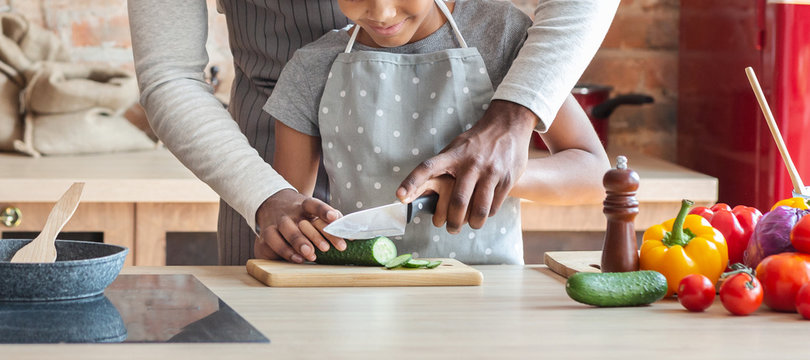 Cropped image of father and daughter cutting vegetables
