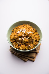 Wheat Laapsi/Lapsi/Shira/Halwa is an Indian sweet dish made of broken wheat or Daliya pieces and ghee along with nuts, raisins and dried fruits. It's a healthy food. served in a bowl, selective focus