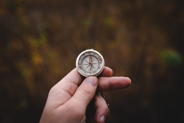 Man hand holding a old compass with broken glass. Travel concept, path selection, navigation,...