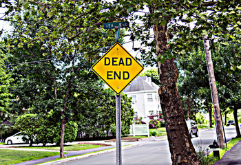 Dead End sign on a town street attached to a signpost
