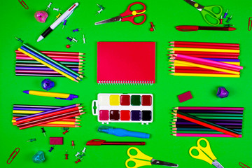 Stationery for school and office lie on a green background.