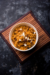 Wheat Laapsi/Lapsi/Shira/Halwa is an Indian sweet dish made of broken wheat or Daliya pieces and ghee along with nuts, raisins and dried fruits. It's a healthy food. served in a bowl, selective focus