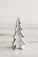 Small Christmas tree of silver color for home decor. New Year and Winter atmosphere