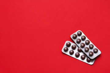 Set of pills blisters isolated on solid red background. Medical concept. Potent drugs. Brown pills.	