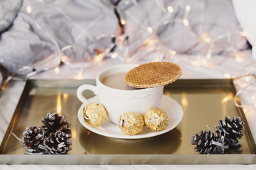 Breakfast in bed, winter season. Coffee with stroopwafel and sweets served on a metal tray. Christmas morning