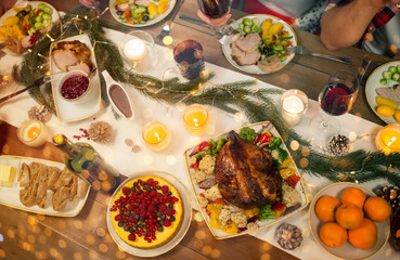 christmas dinner and eating concept - roast chicken or turkey and other food on table