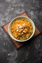 Fototapeta premium Wheat Laapsi/Lapsi/Shira/Halwa is an Indian sweet dish made of broken wheat or Daliya pieces and ghee along with nuts, raisins and dried fruits. It's a healthy food. served in a bowl, selective focus