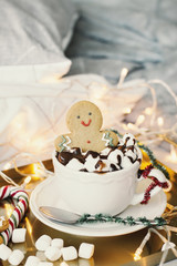 Hot chocolate with marshmallow, sweets and funny gingerdread man. Christmas morning