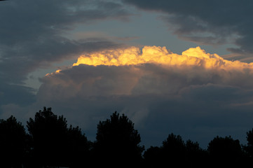 Lit yellow sunlight thundercloud at sunset