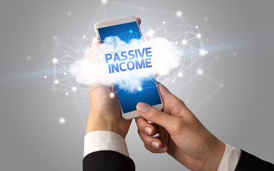 Female hand touching smartphone with PASSIVE INCOME inscription, cloud business concept
