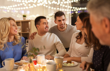 celebration, holidays and people concept - happy family having tea party at home