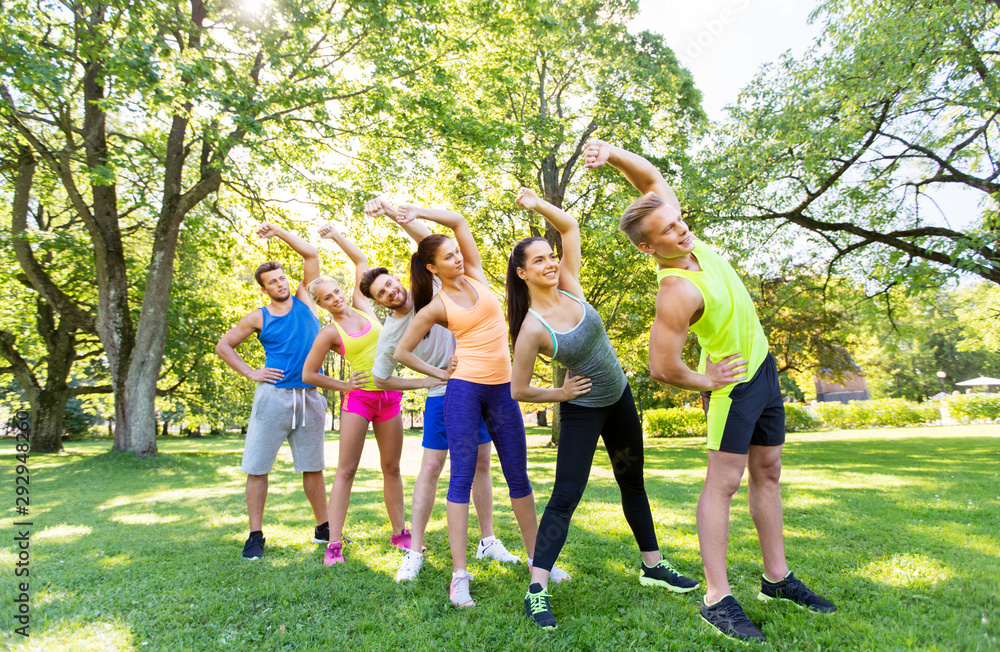 Sticker fitness, sport and healthy lifestyle concept - group of happy people exercising at summer park or bo