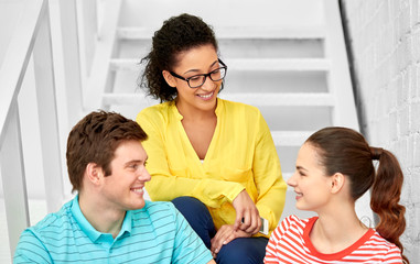 Fototapeta premium friendship and people concept - smiling teenage friends or students hanging out on stairs