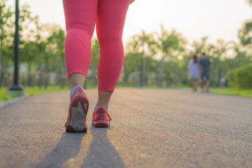 Closeup shoe. Female legs jogging and walking at the park. Sport and exercise concept