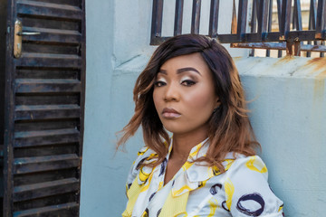 Portrait of an attractive young African lady by a wall