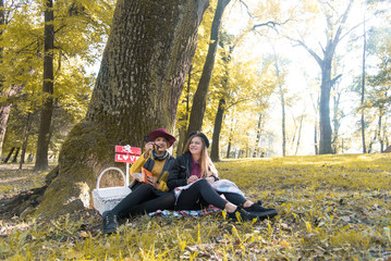 Beautiful young girl resting on street. Emotional conversation sisters. Young students study in nature. Students relax on a picnic after a hard day, doing homework.