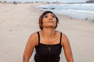 Lady doing a sun salutation yoga pose by the beach