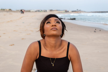 Lady doing a sun salutation yoga pose by the beach