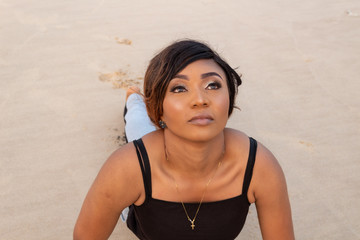 Lady doing a sun salutation yoga pose by the beach