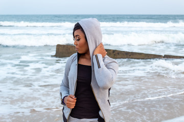 Lady in a hoodie by the beach