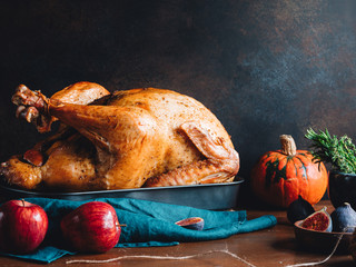 Festive table for Thanksgiving Holiday with whole roasted turkey with apple, pumpkin, figs and...