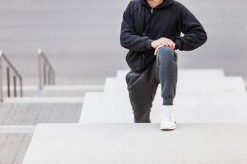 Young slim man student began to run morning jogs in the city park. Concept of the beginning of sports lifestyle and health promotion. Copyspace