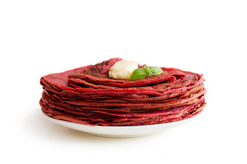 Red beetroot pancakes isolated on white background. Macro view. Tasty thin pancakes
