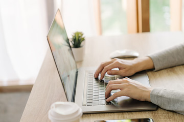 Business woman hand typing laptop computer on wooden table - 292954698