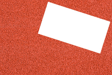 Top view of the white paper card on the red track rubber background. For background , texture , copy text.